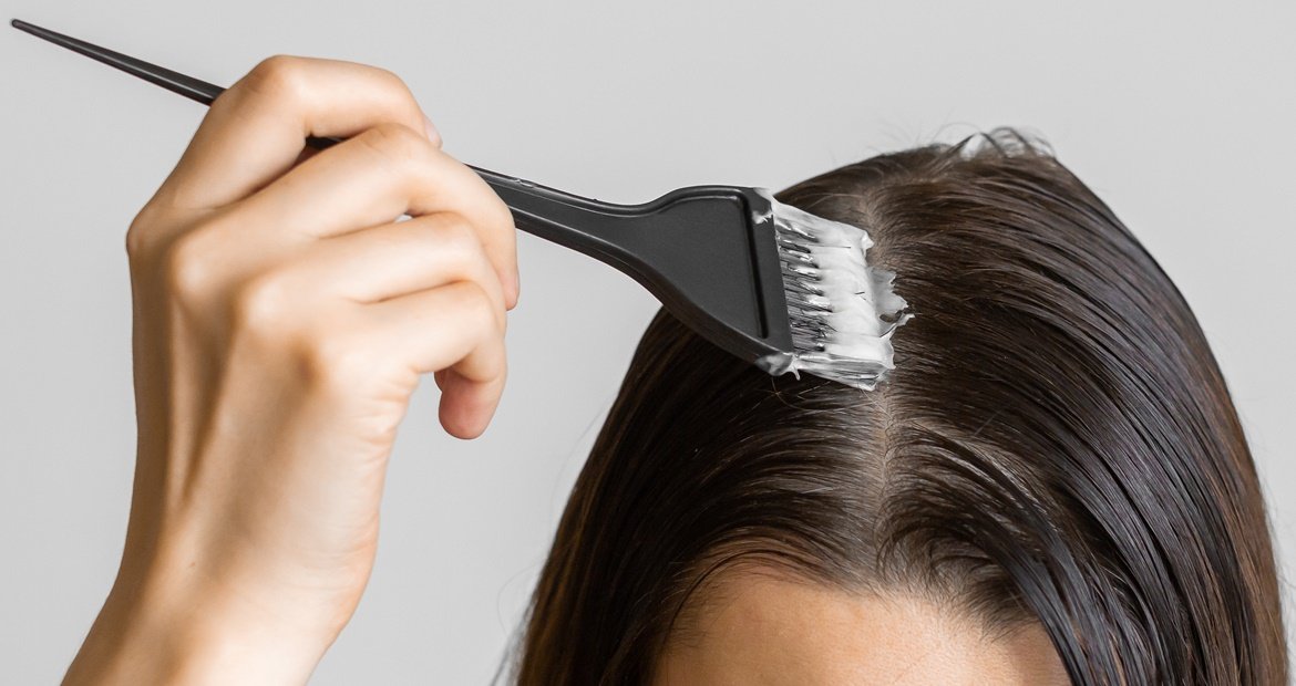 Mulher pintando o cabelo em casa com tinta sem amônia